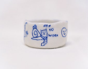 small cup with silly drawings in blue