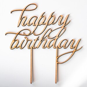 May include: Wooden cake topper with the words "happy birthday" in a cursive script.