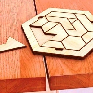 May include: A wooden hexagonal puzzle with a geometric design. The puzzle is made of multiple pieces that fit together to create a complex pattern. One piece of the puzzle is missing.