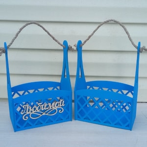 Puede incluir: Dos cajas de madera azules con asas de cuerda. La caja de la izquierda tiene la palabra "Любимый" escrita en blanco.