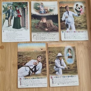 May include: A collection of vintage postcards featuring illustrations and text. The cards depict scenes of couples, soldiers, and individuals in various settings. The text includes song lyrics and titles such as "In the Twi-Twi-Twilight" and "Till the Sands of the Desert Grow Cold."