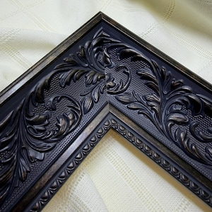 May include: A corner section of a picture frame featuring a dark charcoal finish with bronze-toned highlights. The frame displays an intricate embossed pattern of scrolling acanthus leaves and a textured stippled background with a beaded edge.
