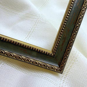 May include: A rectangular picture frame featuring a dark green finish with distressed brown undertones. The frame is accented by a gold-toned inner border with a beaded texture and an outer border decorated with a repeating leaf-like pattern.