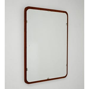 May include: A set of three ceramic mugs with a speckled, cream-colored glaze. Each mug features a different hand-painted design: a blue and green leaf, a yellow flower, and a red berry. The mugs have a simple, modern design.