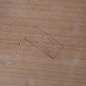 May include: A close-up of a light brown wooden surface with a faint rectangular stamp that reads "Made in USA".