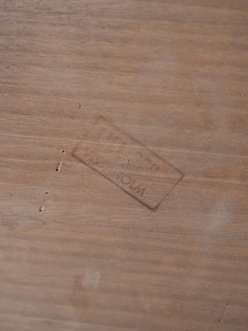 May include: A close-up of a light brown wooden surface with a faint rectangular stamp that reads "Made in USA".
