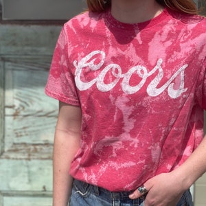 May include: A red tie-dye t-shirt with the word "Coors" printed in white.