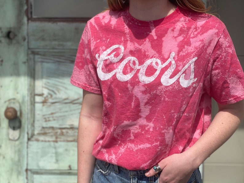 May include: A red tie-dye t-shirt with the word "Coors" printed in white.