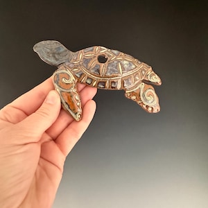 Swimming handmade ceramic sea turtle wall hanging.