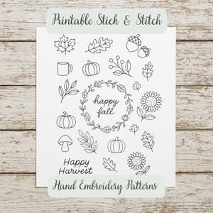 May include: Black and white printable stick and stitch hand embroidery patterns. The design includes fall-themed illustrations such as pumpkins, leaves, acorns, sunflowers, and the phrases "happy fall" and "happy harvest".