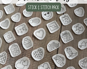 May include: A collection of white fabric stick and stitch embroidery patches featuring black line art designs for Valentines Day. The motifs include hearts, bows, gift boxes, rainbows, cupcakes, and boots, all arranged in a scattered pattern.