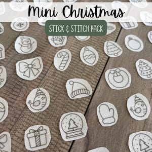 May include: A collection of white fabric patches featuring black line art designs of Christmas icons including snowmen, candy canes, bows, birds, gifts, and trees. The text Mini Christmas STICK & STITCH PACK is printed over the center.