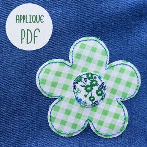 Puede incluir: Una aplicación de flores de tela con un patrón de cuadros verdes y blancos y un centro floral, cosida con hilo azul. La aplicación está sobre un fondo de mezclilla azul. Un círculo blanco con el texto "APPLIQUE PDF" está en la esquina superior izquierda.