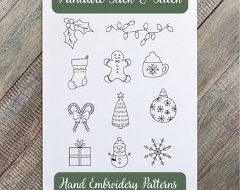 May include: A white sheet featuring black line art for embroidery, labeled Printable Stick & Stitch Hand Embroidery Patterns. The designs include holly, string lights, a stocking, gingerbread man, cocoa mug, candy canes, tree, ornament, gift, snowman, and snowflake.
