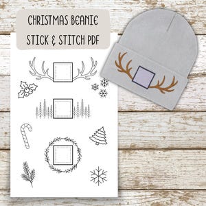 Pode incluir: Um gorro cinza claro com chifres bordados em marrom e um design quadrado. A imagem também mostra uma folha com desenhos de linha com tema de Natal, incluindo chifres, árvores, flocos de neve e uma bengala doce. O texto na folha diz "CHRISTMAS BEANIE STICK & STITCH PDF."