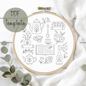 May include: A black and white PDF template for embroidery, featuring a variety of line art illustrations. The design includes teapots, flowers, books, a teacup, and a spoon, all within an embroidery hoop.