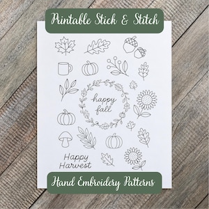 May include: A white sheet featuring black line art embroidery patterns of autumn motifs including pumpkins, acorns, leaves, sunflowers, a mug, and mushrooms. The text reads Printable Stick & Stitch, happy fall, and Happy Harvest Hand Embroidery Patterns.