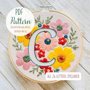 Può includere: Motivo floreale ricamato in un telaio di legno. Il design presenta una grande lettera "C" circondata da fiori colorati rosa, gialli e rossi. Il testo sull'immagine recita "PDF Pattern" e "All 26 Letters Included."