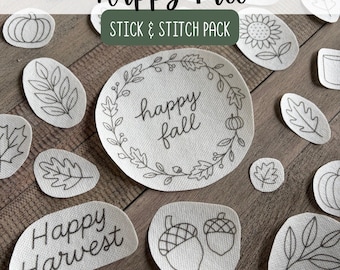 May include: A collection of off-white fabric stick and stitch embroidery patches featuring black line art designs of autumn leaves, pumpkins, acorns, and sunflowers, with text reading Happy Fall and Happy Harvest in a cursive script font.