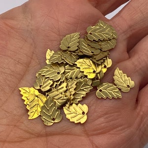 Tiny petite brass leaf stamping. (100 pieces per price )