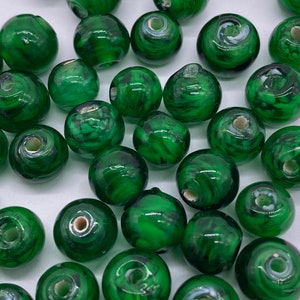 Perla di vetro rotonda da 9 mm. Verde foresta trasparente con turbinii bianchi. (60 pezzi per prezzo)
