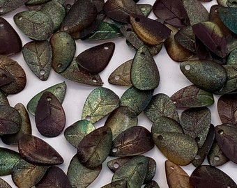 May include: A collection of iridescent green and brown leaf-shaped beads with a hole at the top. The beads have a textured surface and a subtle metallic sheen.