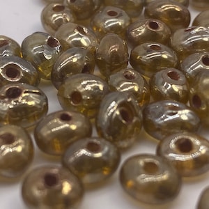 Oval glass beads with irridesent amber gold finish. ( 40 peices per price)