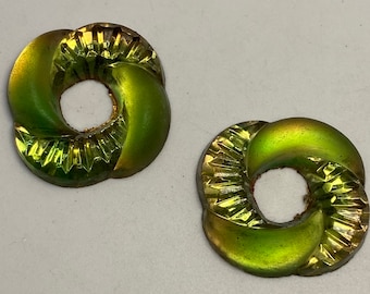 May include: Two green and gold iridescent glass buttons with a twisted design and a hole in the center.