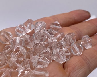 May include: A pile of clear glass beads in the shape of a cone. The beads are faceted and have a shiny finish.