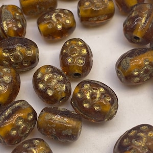 Oval amber and gold glass beads from India. (30 pieces per price)