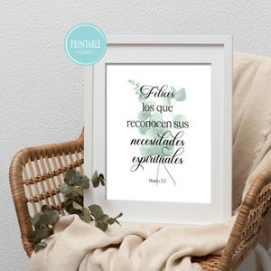 May include: A framed print with the text "Felices los que reconocen sus necesidades espirituales" in elegant script, accented with watercolor eucalyptus leaves. The print is displayed on a woven chair with a neutral-toned blanket.