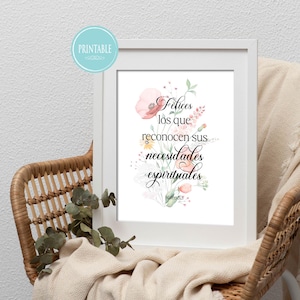 以下が含まれることがあります： 水彩画の花のイラストが施された、スペイン語のテキスト「Felices los que reconocen sus necesidades espirituales」が書かれた額入りのプリント。ニュートラルカラーの毛布がかけられた籐の椅子に飾られています。