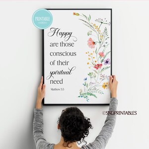 May include: A framed print with the text "Happy are those conscious of their spiritual need" and a floral design. The artwork features a black frame, white background, and colorful watercolor flowers.