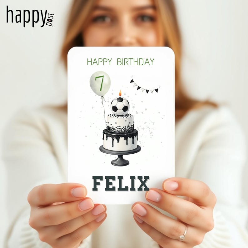 May include: A birthday card featuring a two-tiered cake with a soccer ball on top, a balloon with the number 7, and the name "FELIX". The words "HAPPY BIRTHDAY" are at the top of the card. The card has a black and white color scheme.