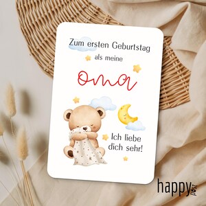 May include: A white card with German text and a cute illustration. The text reads "Zum ersten Geburtstag als meine Oma Ich liebe dich sehr!" with a red "Oma" in the middle. The illustration features a teddy bear, clouds, stars, and a crescent moon.