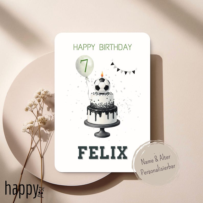 May include: A birthday card featuring a two-tiered cake decorated with black and white sprinkles and a soccer ball on top. The card includes the text "HAPPY BIRTHDAY" and "FELIX", with a balloon displaying the number 7.