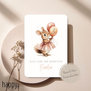 Op de afbeelding: Verjaardagskaart met een aquarel illustratie van een bruin konijn in een roze jurk, met twee ballonnen, waarvan één met het nummer 3. De kaart bevat de tekst "Alles Liebe zum Geburtstag" en de naam "Emilia".