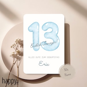 Puede incluir: Tarjeta de cumpleaños con el número 13 en azul claro en fuente de burbujas, con las palabras "Endlich Teenager!" y "Alles Gute zum Geburtstag Eric" en fuente cursiva. La tarjeta está sobre un fondo blanco.