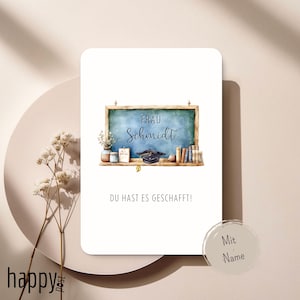 Könnte beinhalten: Eine weiße Karte mit einer Aquarellillustration einer Tafel mit dem Namen "Frau Schmidt" und dem Text "DU HAST ES GESCHAFFT!". Die Tafel hat eine Abschlusskappe, Bücher und Blumen. Ein Kreis mit "Mit Name" befindet sich unten rechts.