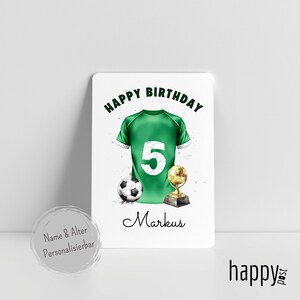 May include: A birthday card featuring a green soccer jersey with the number 5, a soccer ball, and a golden trophy. The words "Happy Birthday" and the name "Markus" are also displayed on the card.