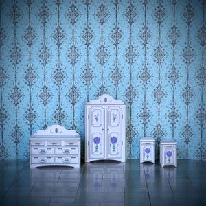 May include: A miniature white bedroom set with blue floral accents. The set includes a dresser, wardrobe, and two nightstands, all against a blue patterned wallpaper background. The floor is a dark, reflective surface.