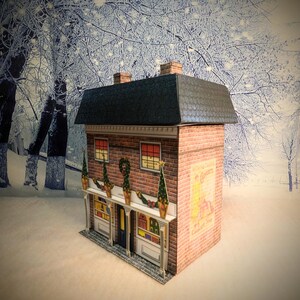 May include: A paper model of a brick building with a black roof and a sign that says "C. Gomery & Son, Wine & Spirit Stores". The building is decorated with Christmas lights and greenery.