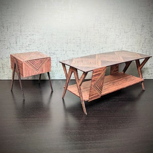 以下が含まれることがあります： 幾何学模様の入った木製のテーブルが2つ。大きなテーブルは棚付きで、濃い色の木材で作られている。小さなテーブルは明るい色の木材で作られており、引き出し付きである。