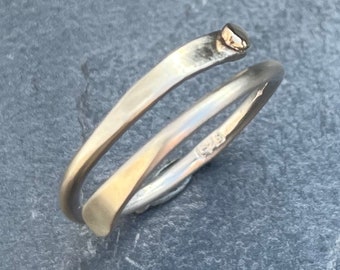 May include: A silver and gold ring with a twisted design. The ring is marked with the number "576".