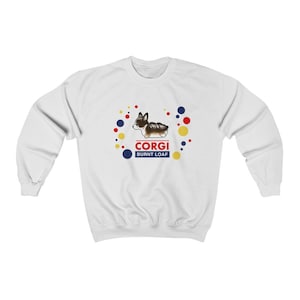 May include: White sweatshirt with a cartoon corgi dog wearing a red collar and a blue and yellow background. The text "CORGI BURNT LOAF" is printed on the sweatshirt.