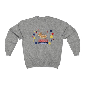May include: A heather gray sweatshirt featuring a cartoon corgi dog illustration. The design includes the word "CORGI" in red, with "CLASSIC LOAF" below in blue. Colorful dots surround the corgi image, creating a playful aesthetic.