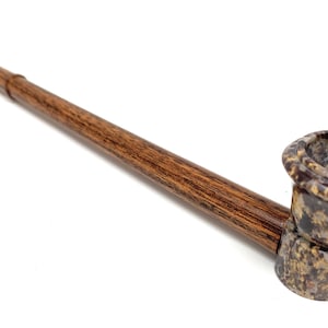 Könnte beinhalten: Eine Holzpfeife mit einem braunen und schwarzen marmorierten Kopf. Die Pfeife hat einen langen, schlanken Schaft.