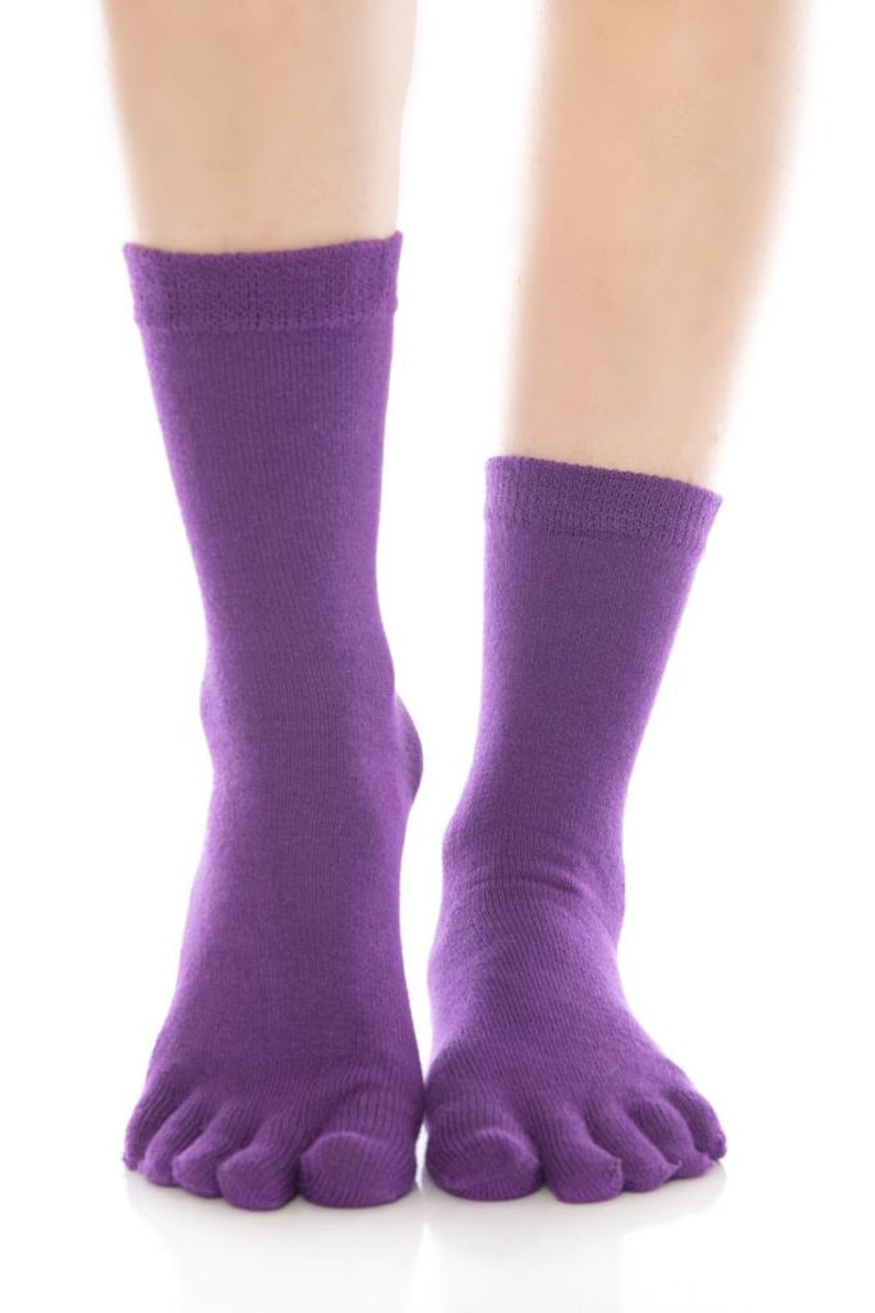 May include: A pair of purple toe socks with five individual toe compartments. The socks are made of a soft, stretchy fabric.