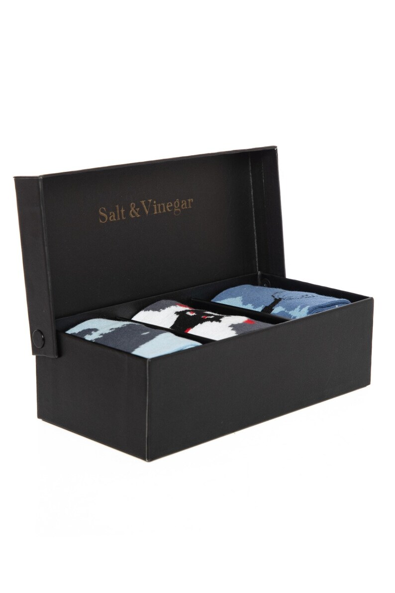 Puede incluir: Una caja negra con el texto dorado "Salt & Vinegar" en la tapa interior. La caja contiene tres pares de calcetines estampados en tonos de azul, negro, blanco y rojo.