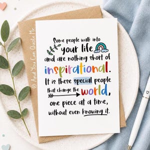 May include: A white greeting card with black text that reads: Some people walk into your life and are nothing short of inspirational. It is these special people that change the world, one piece at a time, without even knowing it. The card features a small rainbow, a leaf sprig, and an arrow graphic with colorful lettering.